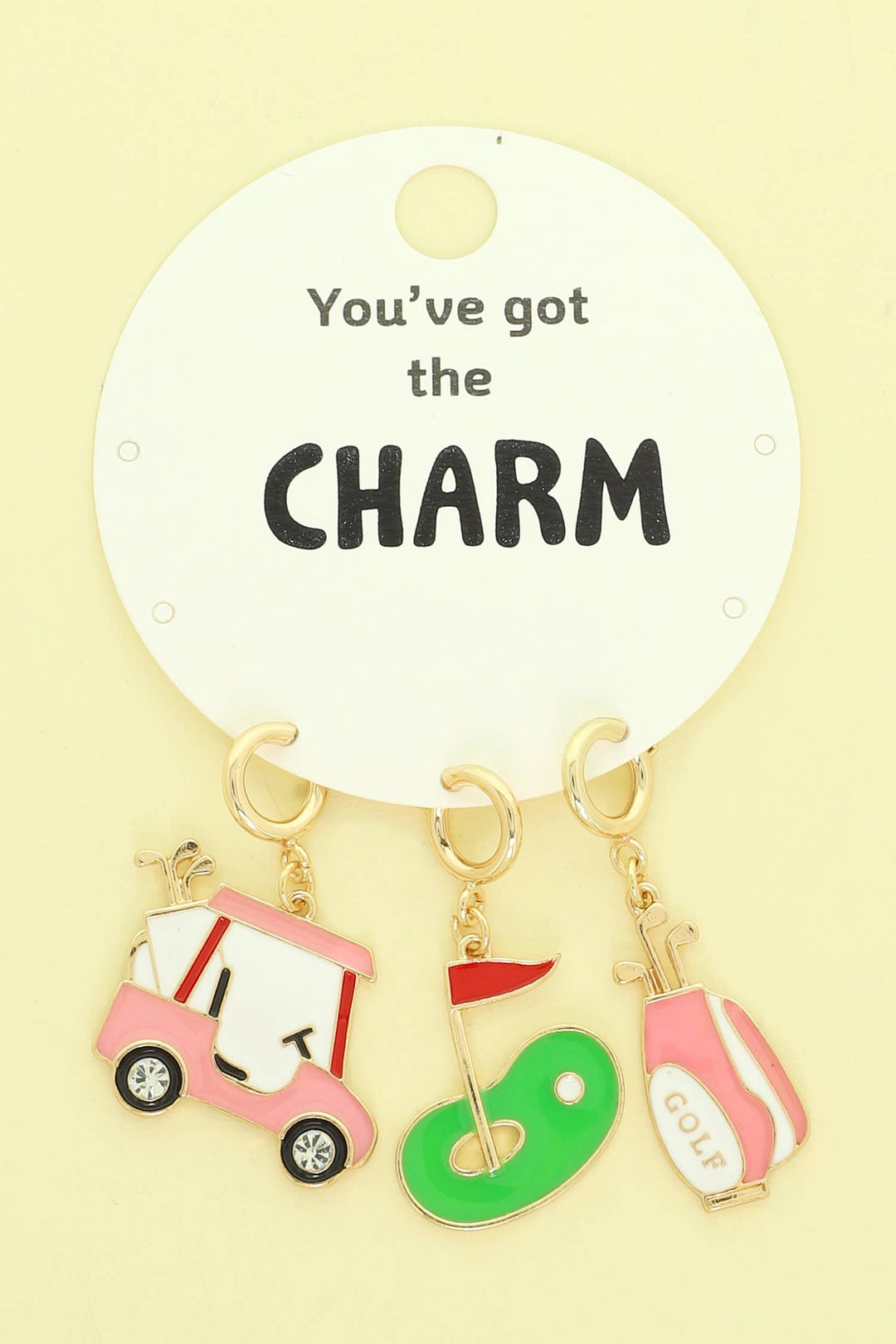 Set of three enamel charms—golf cart, putting green, and golf bag—on a card that reads "You’ve got the CHARM." Sizes not listed.