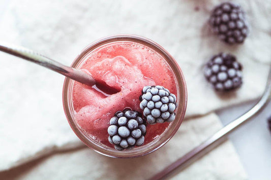 Wine & Cocktail Slush Mix Bags smoothie in a glass with metal straw; available in small, medium, and large sizes.