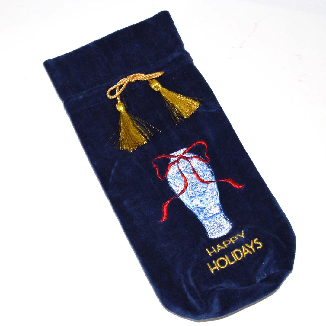 Navy blue velvet wine bag featuring an embroidered ginger jar with a red bow, “HAPPY HOLIDAYS” text, and a gold tassel drawstring.