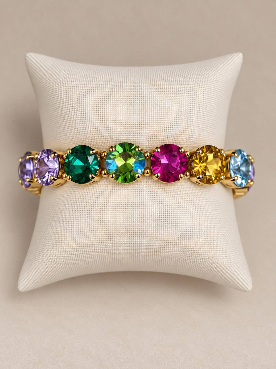 Multi-colored faceted stretch bracelet with round, gold-tone settings.