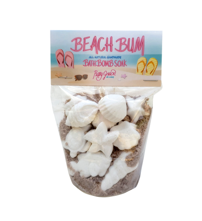 Beach Bum Bath Soak in clear pouch with beach graphics, includes seashell bath bombs and sand-colored salts. Sizes: 4oz, 8oz.