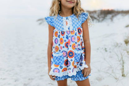 Girls Blue Check Flower Power Short Set with retro floral prints in orange, red, and purple. Available in sizes 2-10.