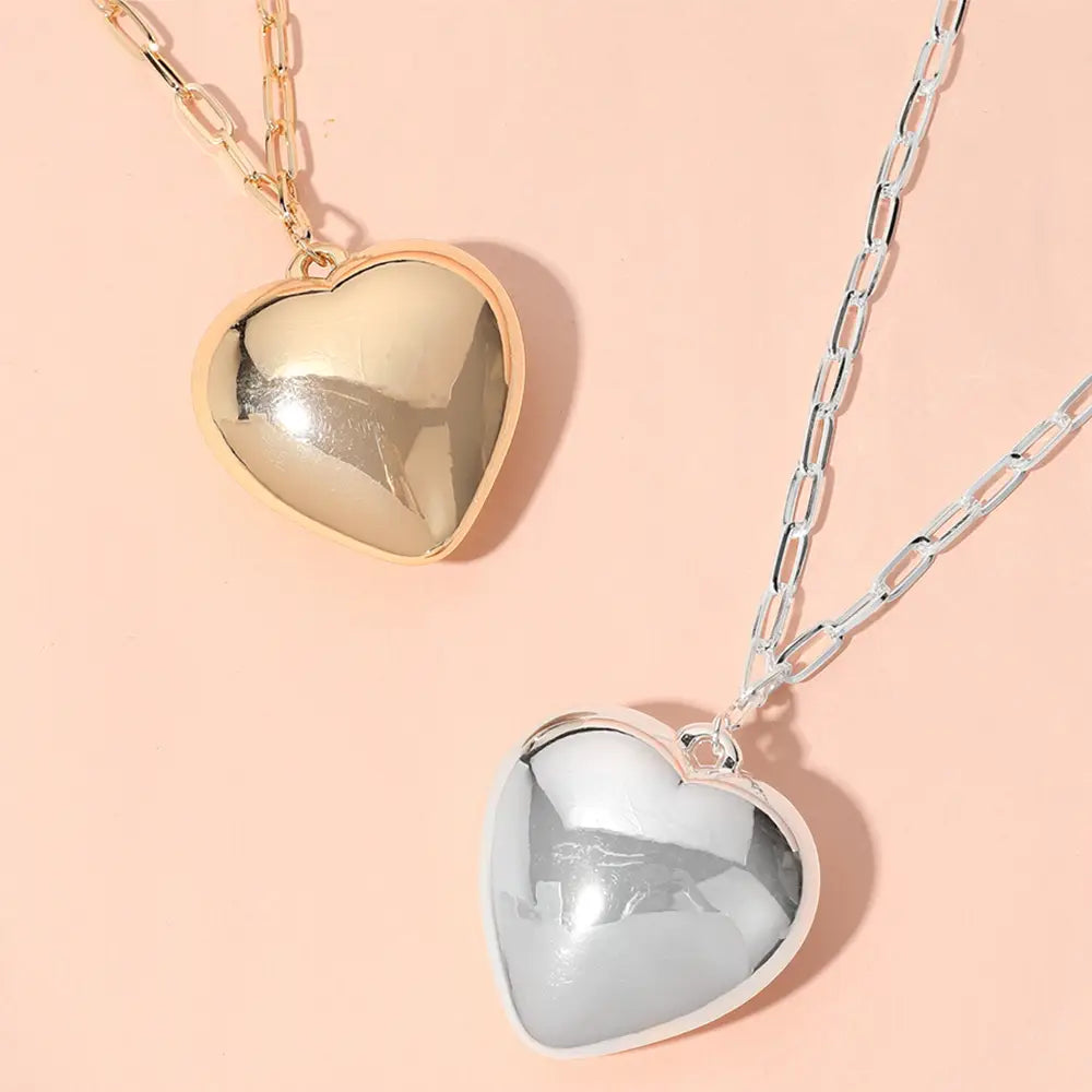 The Metal Puffy Heart Pendant Paperclip Chain Necklace is available in gold and silver. It features a heart-shaped pendant and a paperclip chain, lead and nickel compliant, with a polished, reflective finish. Available sizes: 18 inches (chain length).
