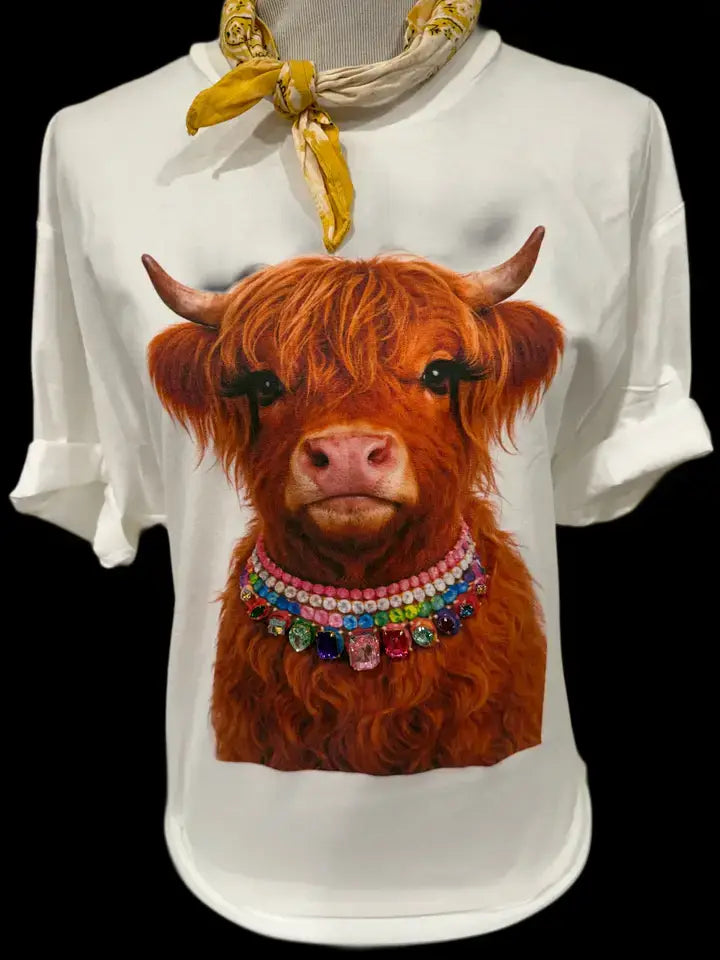 Light pink crewneck t-shirt with a detailed print of a long-haired Highland calf wearing a jeweled collar and fluttery false eyelashes. Available in sizes M.