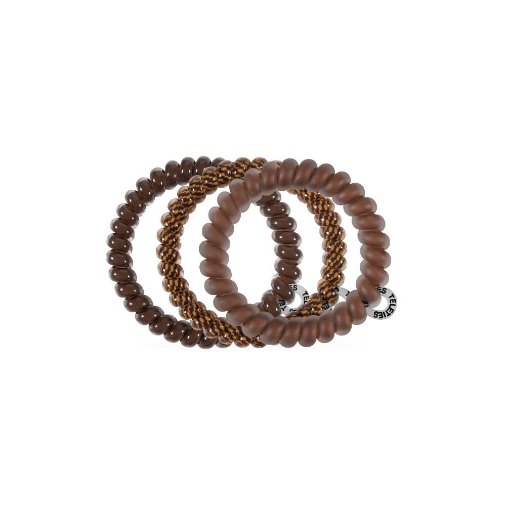 Three waterproof Morning Brew Small Hair Ties in brown tones, each with a unique texture—smooth, matte, and braided with gold accents—plus a silver tag. Available in small size. No-crease, gentle on hair.
