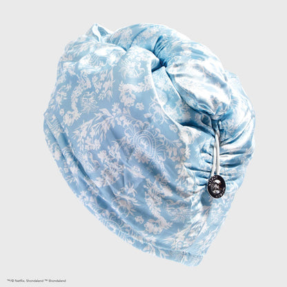 Light blue satin hair towel with white floral pattern, drawstring, and silver button. Available in one size.