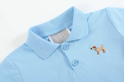Light blue polo shirt with collar, two buttons, dog with sunglasses patch; white inner tag. Sizes: XS, S, M, L, XL.