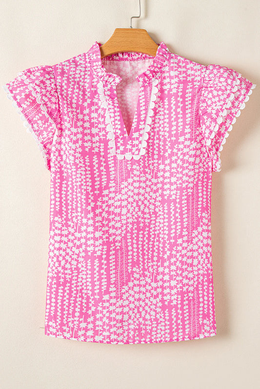 Pink and white abstract print blouse with short flutter sleeves, ric rac trim, and split V-neckline. Available in sizes XS-XL.