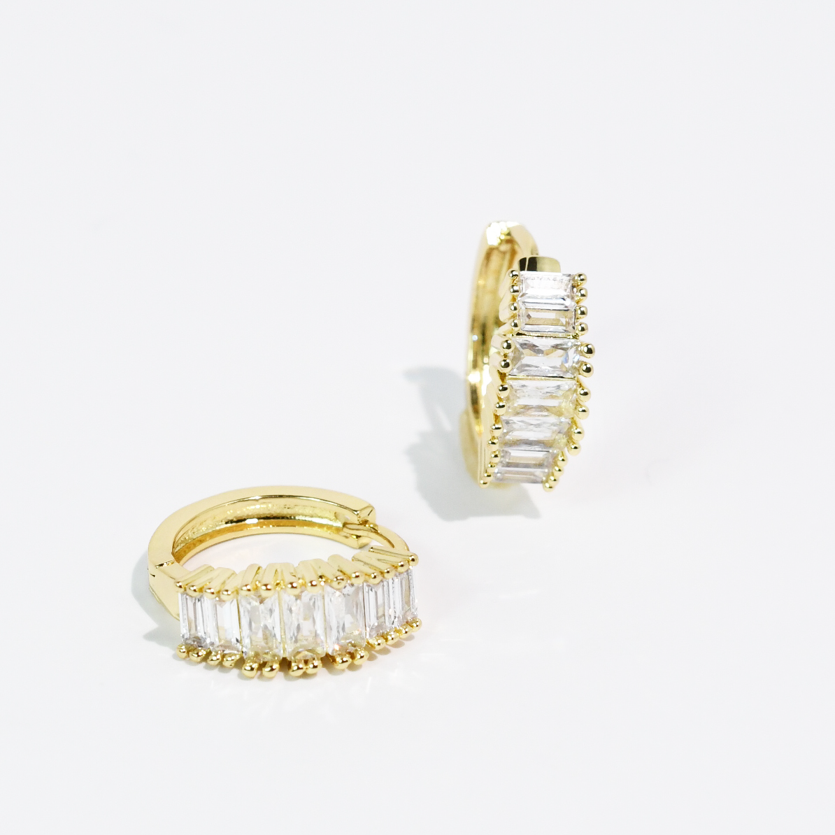 Sugar Spark Huggies Gold: classic gold hoop earrings with rectangular clear gemstones. Available in 10mm, 12mm, and 15mm sizes.
