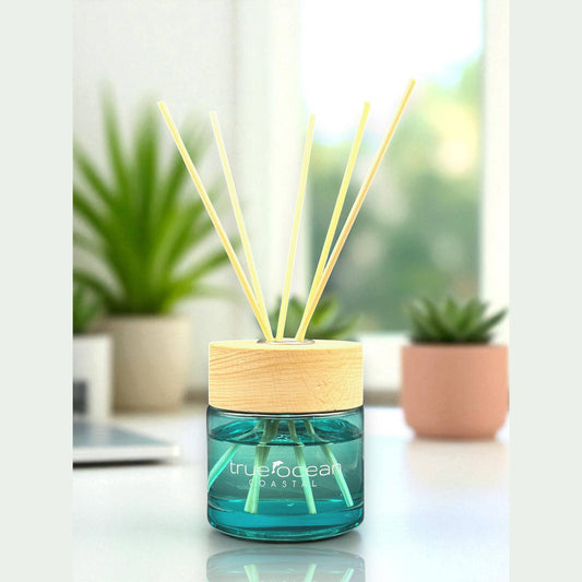The True Ocean: Reed Diffuser features blue glass, wooden cap, and reed sticks. Available in 100ml and 200ml sizes.