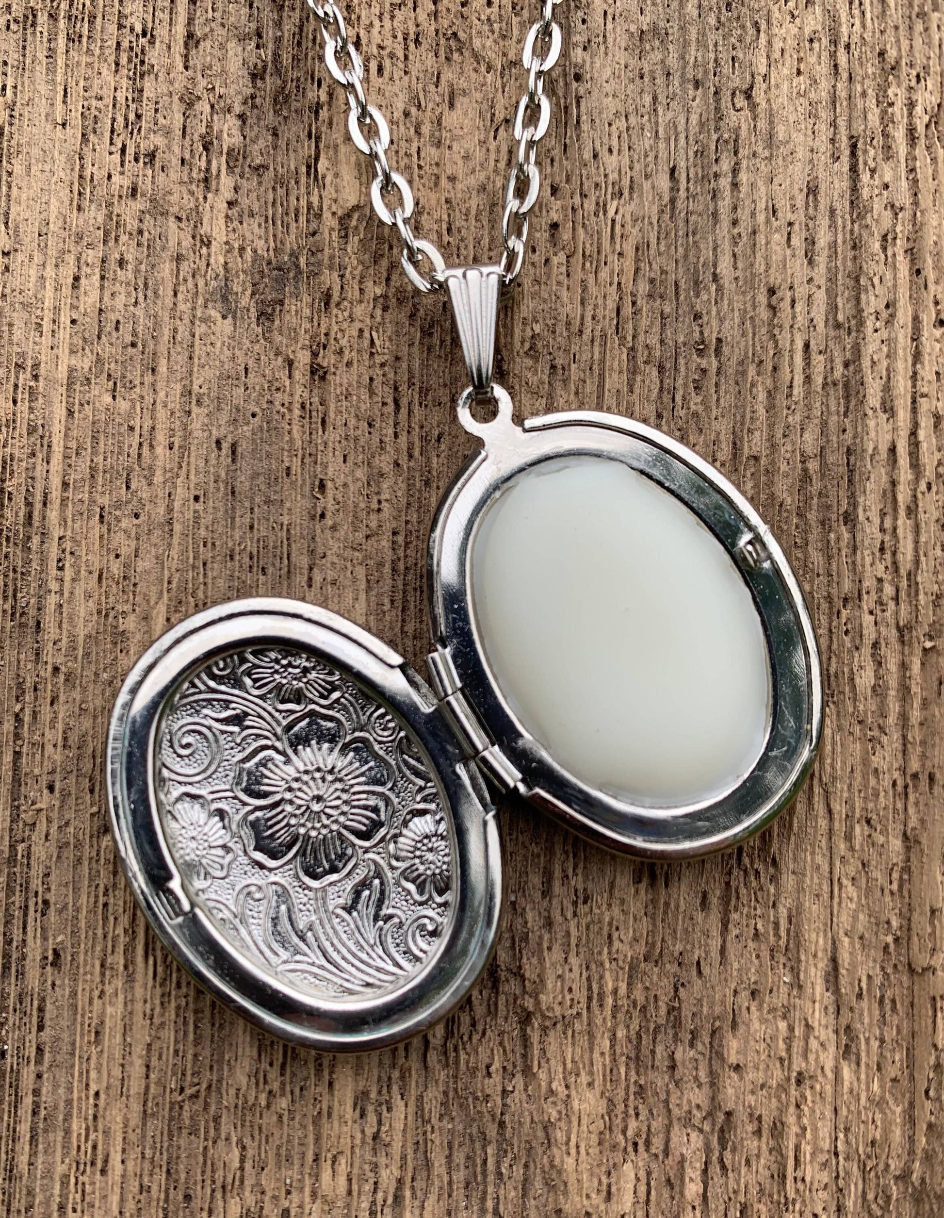 Oval antiqued silver locket on chain with embossed floral design, holds Moonflower solid perfume. Sizes: S, M, L.