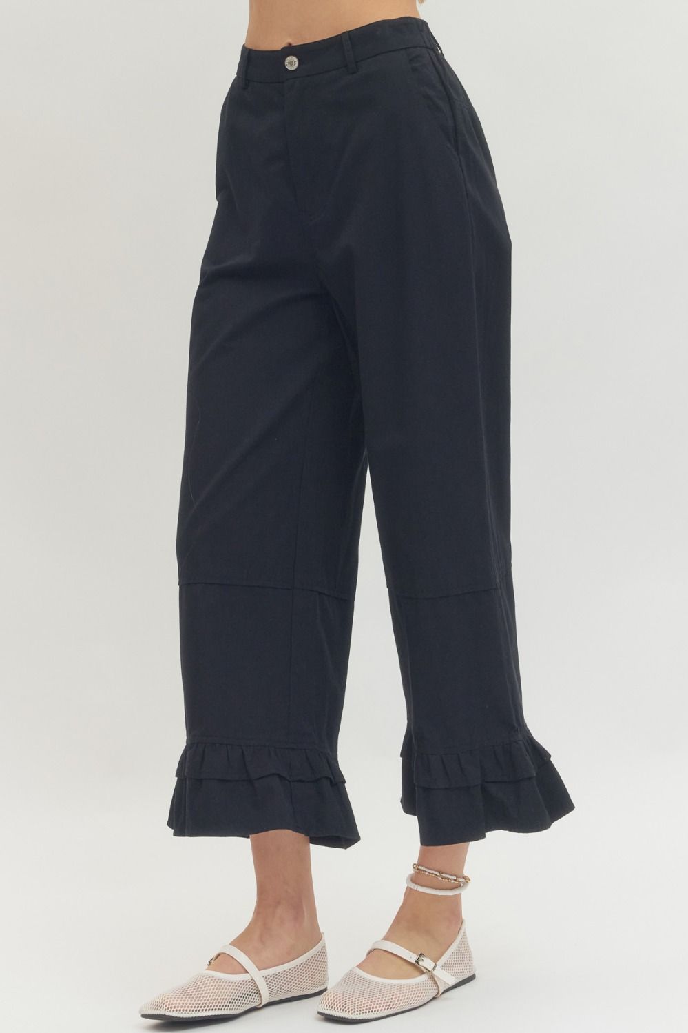 Black straight leg ruffle hem pants with cropped fit; available in sizes XS–XL.