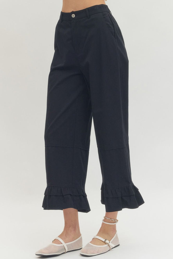 Black straight leg ruffle hem pants with cropped fit; available in sizes XS–XL.