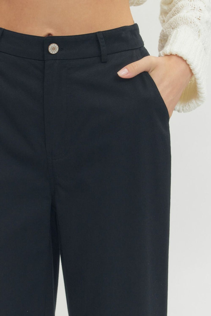 Black Straight Leg Ruffle Hem Pants with visible waistband and button. Available in sizes XS-XL. Cream sweater not included.
