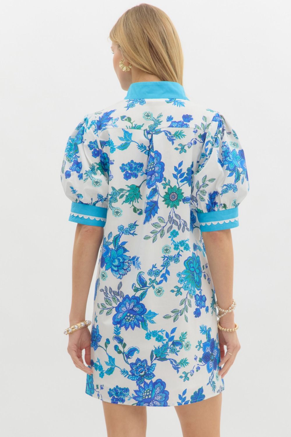 Blue Blossom Caftan Mini Dress featuring A-line silhouette, light blue collar and cuffs, puffed sleeves, and blue floral patterns. Available in sizes XS–XL.