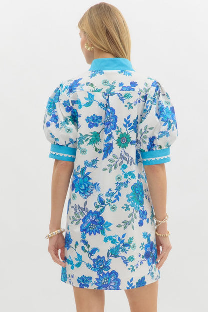 Blue Blossom Caftan Mini Dress featuring A-line silhouette, light blue collar and cuffs, puffed sleeves, and blue floral patterns. Available in sizes XS–XL.