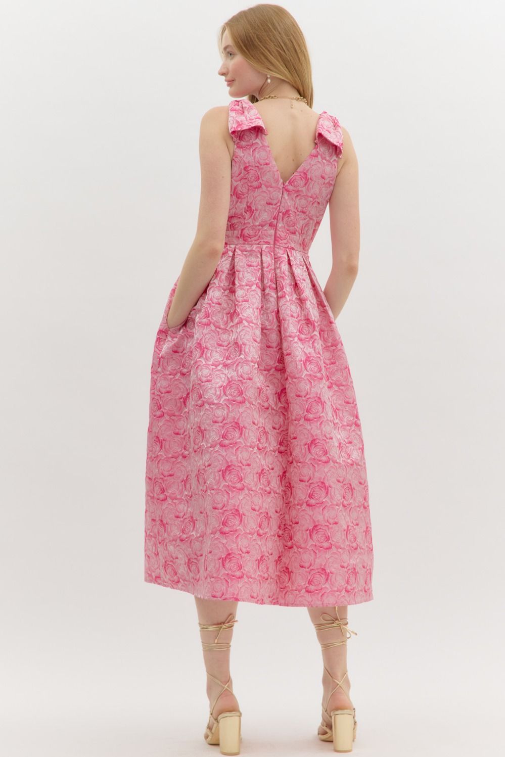 Pink Carly Floral Print Bow Accent Midi Dress features shoulder bows, a V-back, pleated skirt, and floral texture. Available in sizes XS-XL.