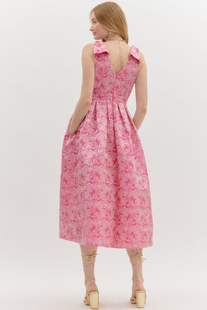Pink Carly Floral Print Bow Accent Midi Dress features shoulder bows, a V-back, pleated skirt, and floral texture. Available in sizes XS-XL.