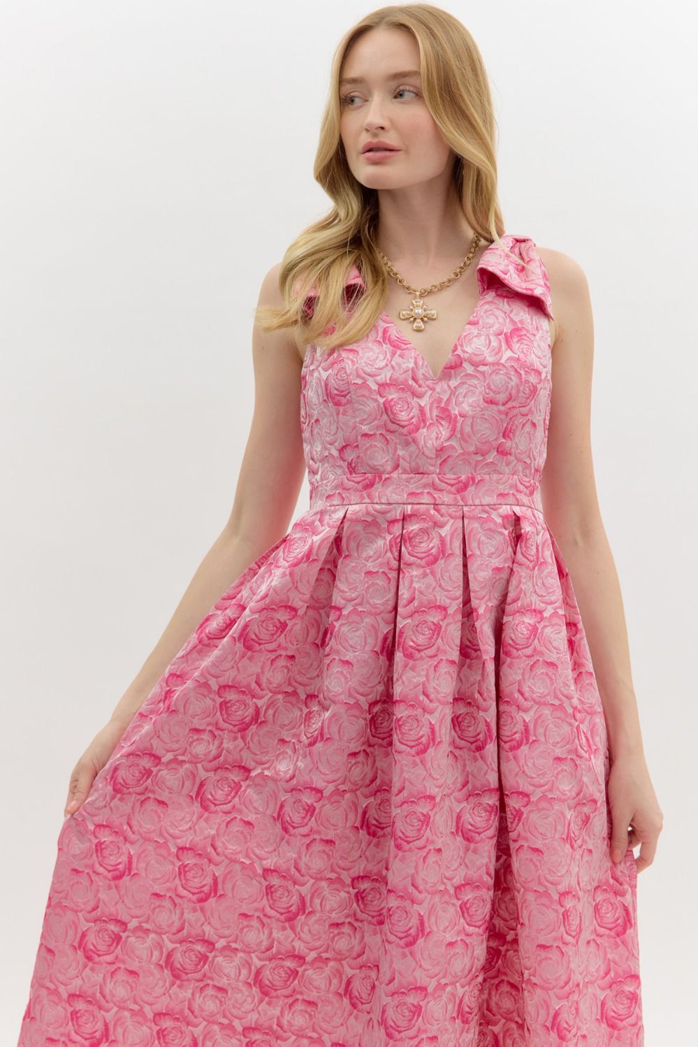Carly Floral Print Bow Accent Midi Dress features a pink floral pattern, midi length, and a bow detail on the shoulder. Available in sizes XS–XL.