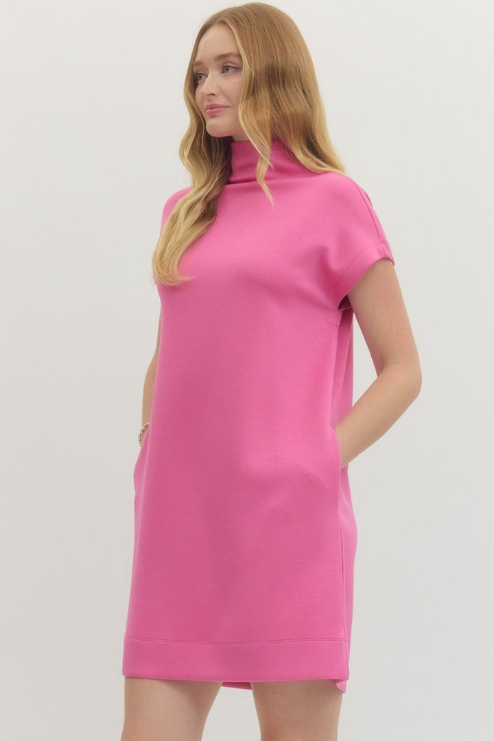 Bright pink mock neck pullover dress, short sleeves, pockets, knit fabric. Available in sizes XS-XL.