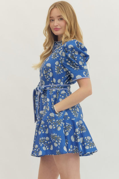 Blue Floral Print Belted Dress with puff sleeves, self-tie waist belt, ruffled hem. Available in sizes XS-XL.