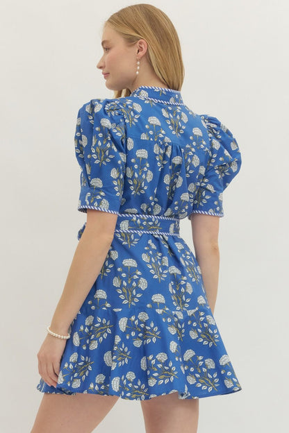 Blue Floral Print Belted Dress with puffed sleeves, ruffled hem, and self-tie back belt. Available in sizes XS-XL.