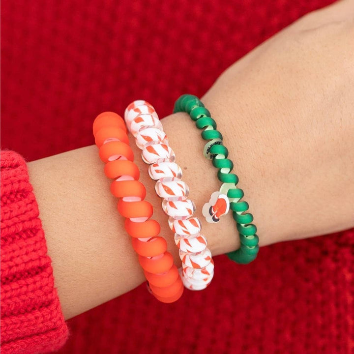Three Claus I said So hair ties, small: one solid red, one white with red swirls, and one green with a small cherry charm.