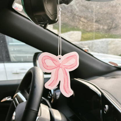 Sweet Ride Car Air Freshener–Bow Pink hangs from mirror; available in small and large sizes; delivers long-lasting fragrance.