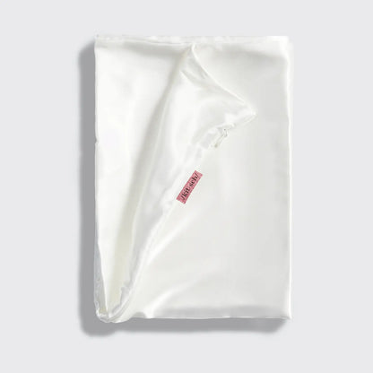 Ivory Satin Pillowcase: Frizz-free, silky texture, adorned with a small red tag. Available in Standard, Queen, and King sizes.