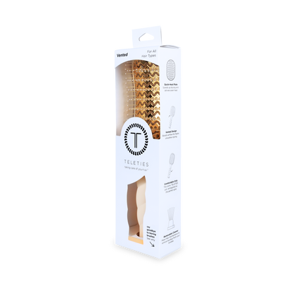 Vented Hair Brush | Tan displayed in a white box with clear window; features a gold vented design and quick-heat aluminum plate. TELETIES logo on packaging. Available sizes: Regular and Large.