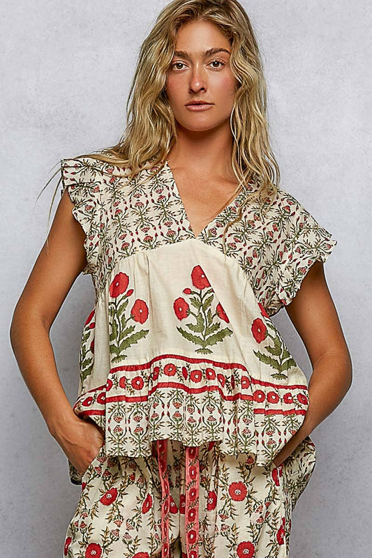 Cream V-neck top with ruffle sleeves, red poppy and green leaf print. Available in sizes XS–XL.