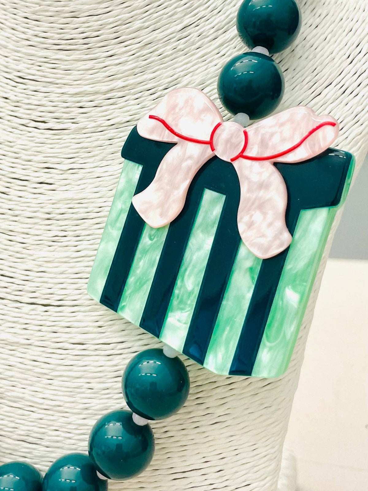 The HOLIDAY - Beaded Gift Necklace (green) BNK1215 features large green beads and a green gift box pendant with a pink bow. Available in multiple sizes.