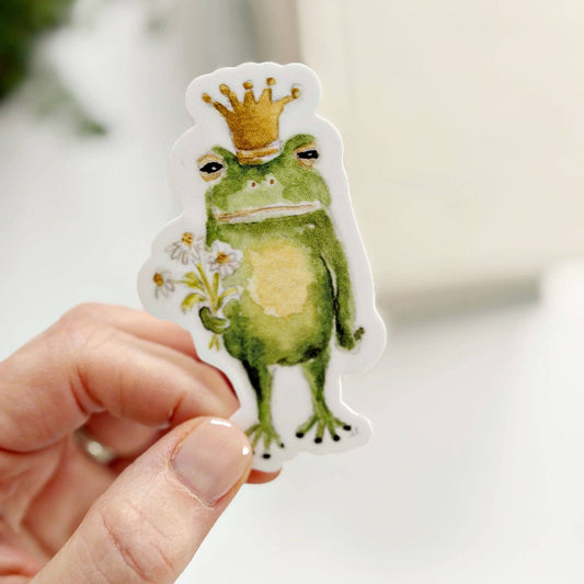 Frog Prince Sticker with green frog, gold crown, white daisies. Watercolor style. Available in multiple sizes.