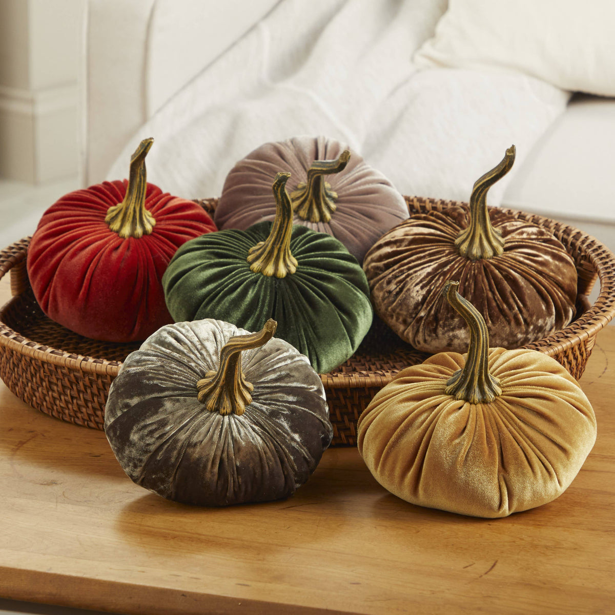 Six plush velvet pumpkins in red, green, brown, taupe, gray, and gold from the Pumpkin Large Velvet collection (Fern), arranged in a woven basket. Available in multiple large sizes.