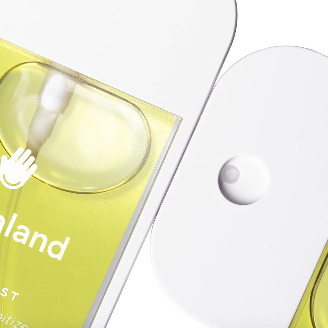 Vanilla Blossom Power Mist Hydrating Hand Sanitizer spray bottle, flat rectangular shape, white nozzle, pale yellow liquid.