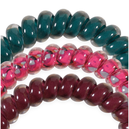 The Harvest Hues Small Hair Ties set includes three small spiral coil hair ties in green, pink with a floral print, and maroon. Available in small size.