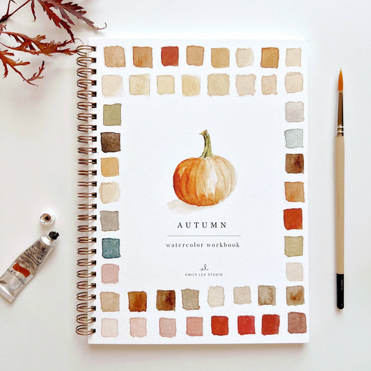 The Autumn Watercolor Workbook is a spiral-bound guide for beginners with a pumpkin cover and fall illustrations. Sizes: standard.
