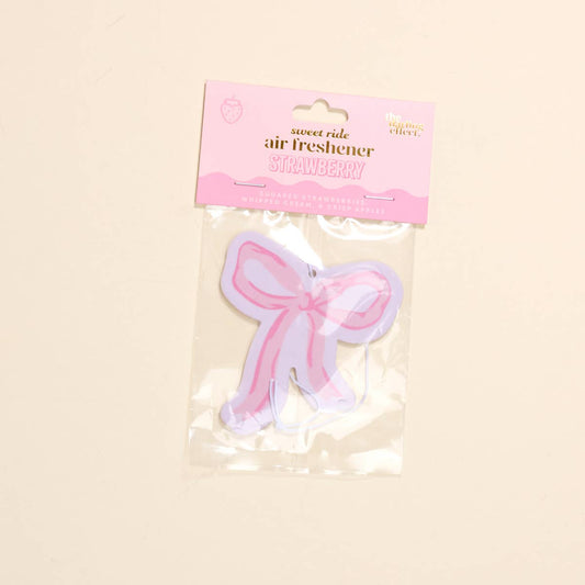 Sweet Ride Car Air Freshener–Bow Pink: pink bow shape, clear packaging, pink "STRAWBERRY" label. Size options available.