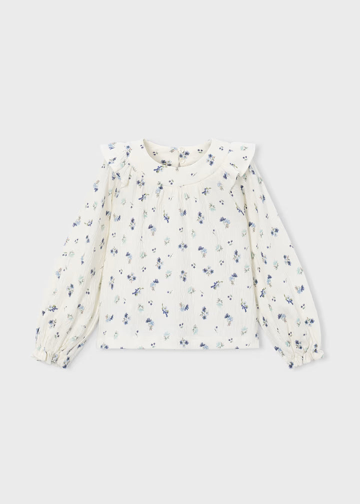 White crinkle cotton blouse with long sleeves, ruffled collar, small blue floral print, front pleats, ruffle accents, and elastic cuffs. Available in sizes 2T-6X.