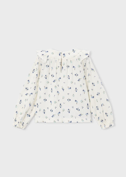 White long-sleeve crinkle cotton blouse with blue and green floral print, ruffled collar, pleated detailing, and elastic cuffs. Available in girls’ sizes 2T–6X.