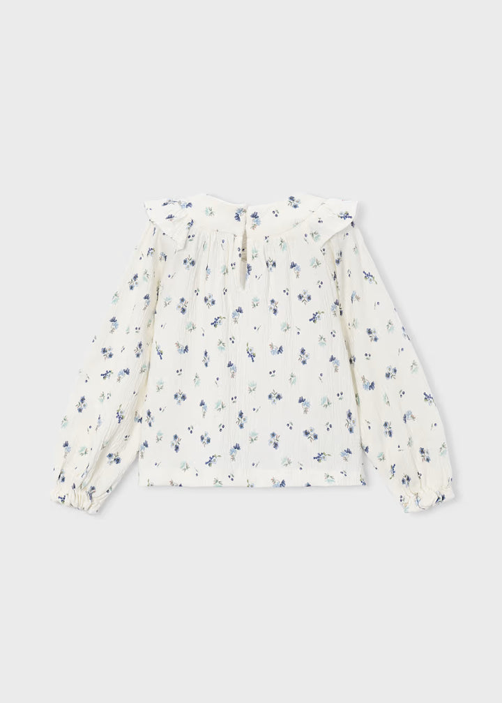 White long-sleeve crinkle cotton blouse with blue and green floral print, ruffled collar, pleated detailing, and elastic cuffs. Available in girls’ sizes 2T–6X.