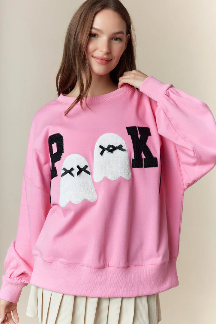 Oversized Spooky Boo Pink Patch Sweatshirt with bold black “P” and “K” letters, plus two white lace ghost patches with “X” eyes. Available in sizes S–XL.