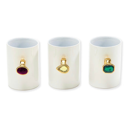Set of three white ceramic mugs with gold ring handles and gem designs; available in one standard size.
