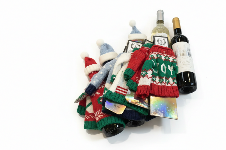Wine Hat &amp; Sweater Set with holiday-patterned knit sweaters and pom-pom hats for wine bottles. Available in one size.