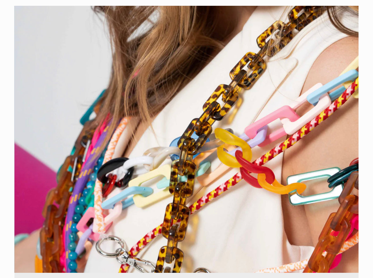 Product consists of multiple colorful plastic chain necklaces with a variety of patterns and styles. The chains are combined with adjustable crossbody phone straps for versatility. Sizes are available upon request.