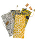 Four cotton wine bags in yellow, blue, green, and black patterns, each with a drawstring and tag. Available in standard size.