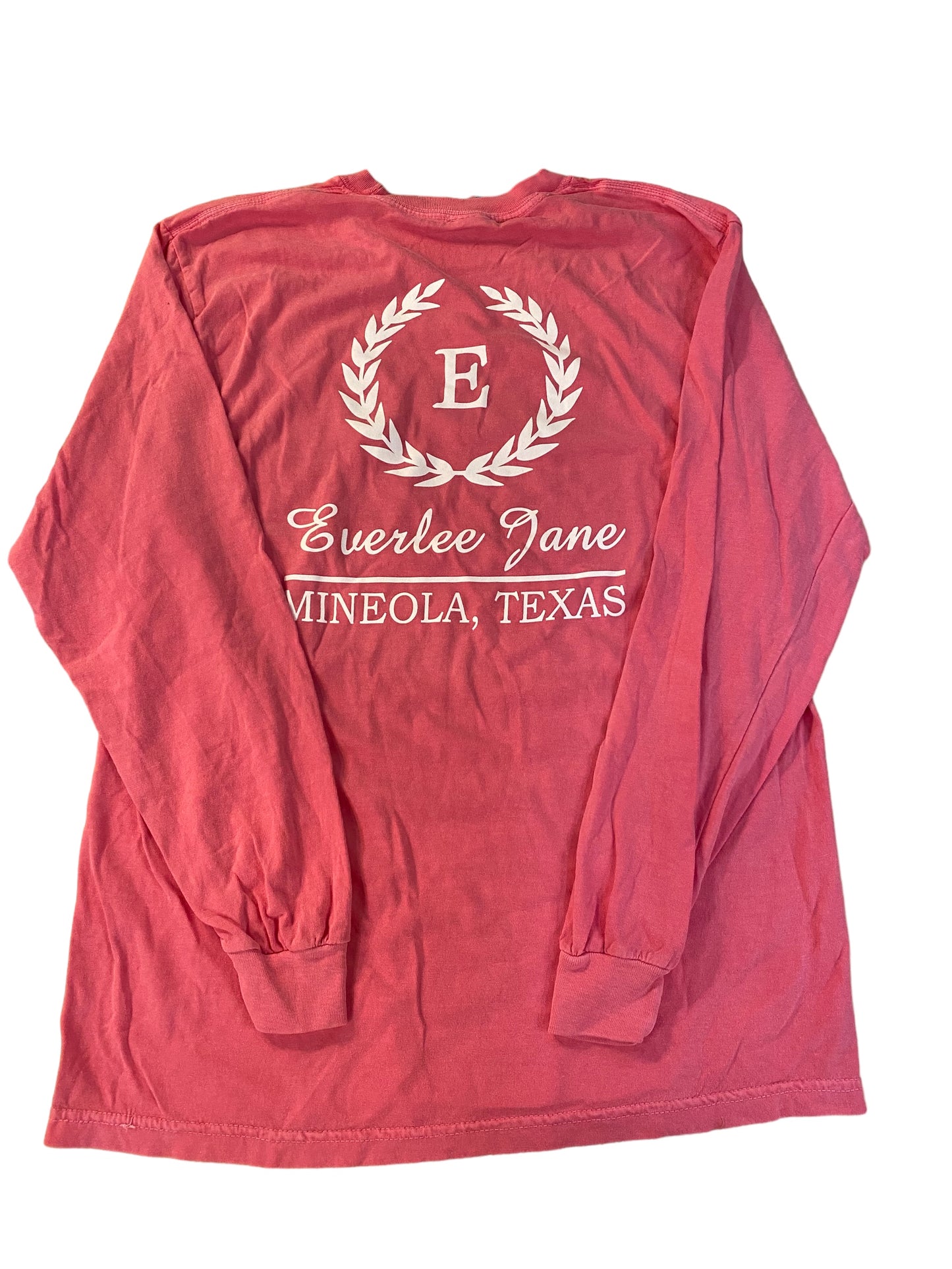 A red long-sleeved Everlee Jane T-Shirt LS with the white text "everlee jane" and "mineola, texas" centered inside a white laurel wreath design, displayed on a flat