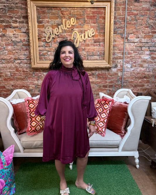 Plum Satin Tie Neck Dress: satin mini dress with high ruffle mock neckline. Available in sizes XS–XL.