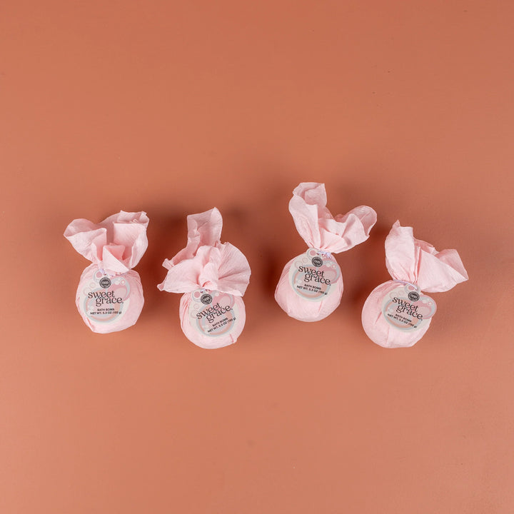 Four Sweet Grace Bath Bombs with fragrance, wrapped in pink tissue, each labeled. Available sizes: standard only.