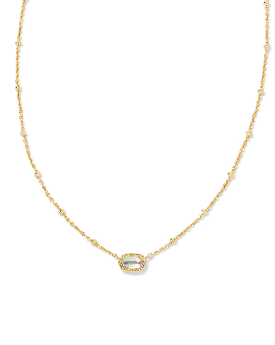 Mini Elisa Gold Satellite Short Pendant Necklace in Dichroic Glass by Kendra Scott, with pearl-like beads on a gold chain and an oval dichroic glass pendant encircled by clear stones. Available in standard necklace length (16″ chain with 2″ extender).